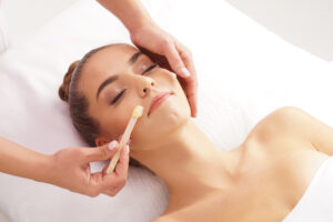 Beautiful woman experiencing facial waxing service